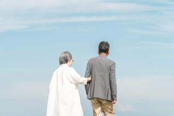 公園・旅行先を話しながら歩く高齢者夫婦（シニア・男女）
