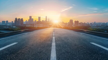 Obraz premium Urban Sunset Road: Majestic City Skyline with Open Asphalt Foreground and Blue Sky Sun Flare - Ideal Advertising Backdrop