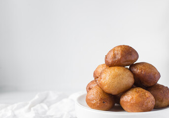 nigerian puff-puff on a white plate, nigerian fried dough balls, flatlay of homemade bofrot on white dish