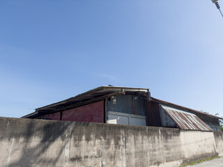 Fototapeta premium An old red barn and a white silo stand tall against a clear blue sky in the countryside