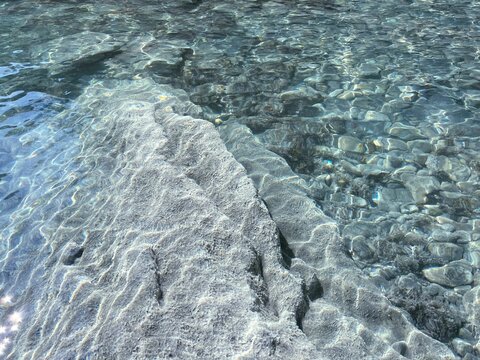 Transparent water with stones and pebbles.