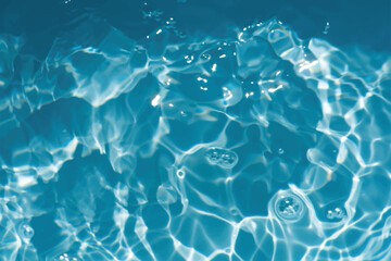 Blue water with ripples on the surface. Defocus blurred transparent blue colored clear calm water surface texture with splashes and bubbles. Water waves with shining pattern texture background.