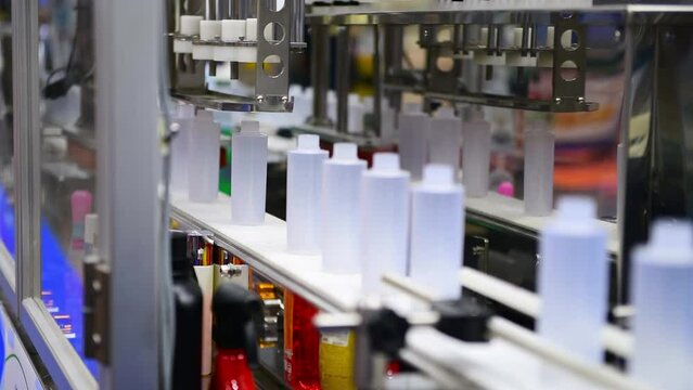 White plastic bottles in a conveyor belt on a high quality automatic vertical filling machine. in the factory production line