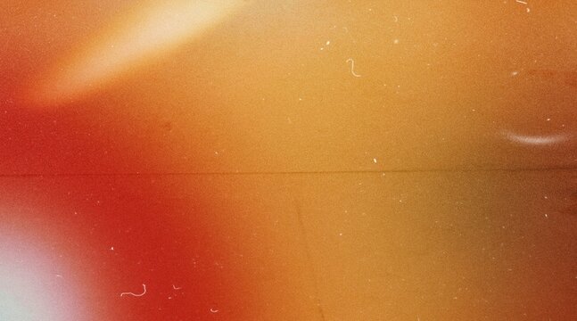 grainy colorful warm orange light leaks on black background with dust texture. abstract damaged scratched retro film analog effect for using over photos as overlay or screen filter