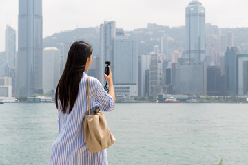 Tourist woman use camera to take photo in Hong Kong city