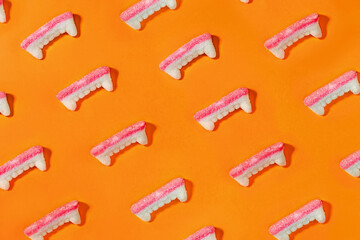 Creative Halloween background with gummy vampire teeth candies