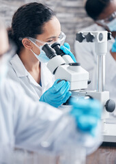 Woman, scientist and research with microscope for investigation and medical innovation with ppe...