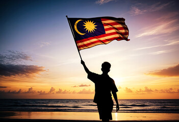man holding malaysia flag on beach at sunset
