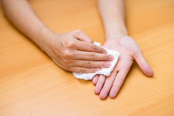Woman suffer from hand perspiration clean up with tissue