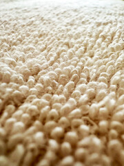 Closeup view of a pastel colored towel. Soft background pattern, White Rug. Carpet knitting