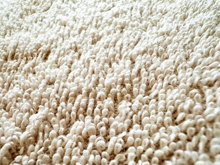 Closeup view of a pastel colored towel. Soft background pattern, White Rug. Carpet knitting