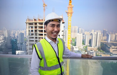 happy asian engineer man in safty shirt on high building