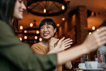 Two female friends engaged in a lively conversation during lunch in the restaurant