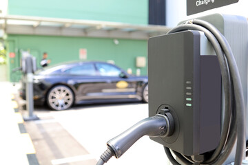 electric car charger plug. Power supply for electric car charging. Socket for electric car battery charger. EV car charging station in parking lot.