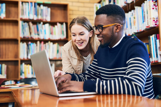 Student, woman and laptop in library for research, studying and exam preparation on campus. Team, education and technology with smile for knowledge, social media and learning on internet with help