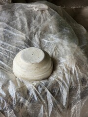 White spherical ceramic on crumpled plastic. A study in texture and form.
