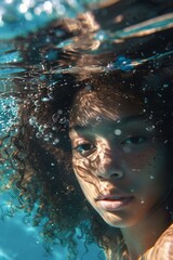 Underwater portraits of curly-haired women, underwater photography soft light and deep blue water create shadows. In fashion style fashion magazine cover editorial style with surrealistic style