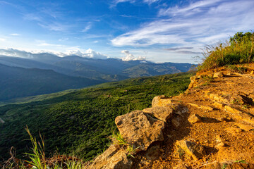 View from the most known El Camino Real trail in Barichara, Colombia. The trail is surrounded by lush greenery and offers stunning views of the surrounding hills of Andes mountains.