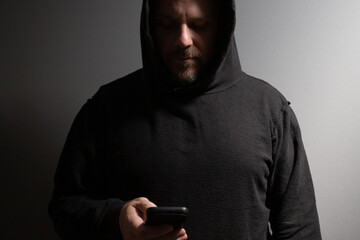 Robber, a man typing on the phone, hacker organizing crime, felon discussing vandalism, masked...