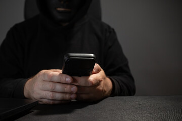 Man in a mask with a phone, scammer, swindler, impostor.
