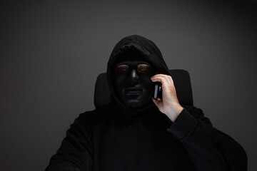 Man in a mask with a phone, kidnapper, rogue, rascal.