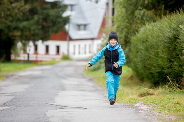 Two children, brothers, walking on a path in a park autumn day