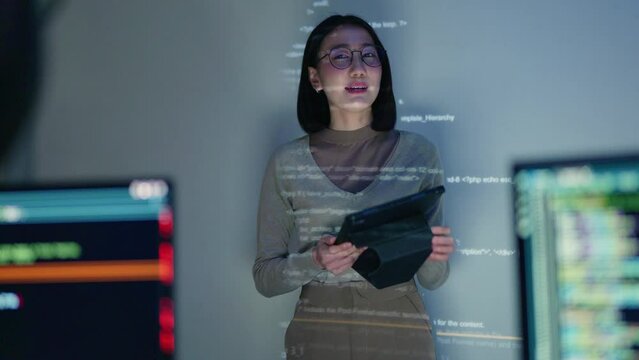 A female developer presents a coding workshop, projected with HTML code, in a collaborative office. Showcasing the dynamic role of women in software engineering and development.