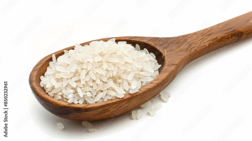 Wall mural wooden spoon filled with polished white rice on isolated white background