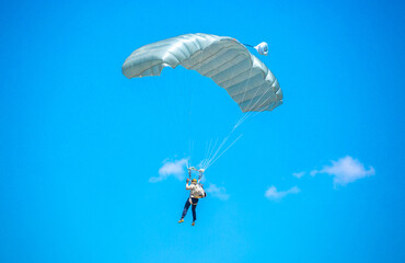 Skydiving. Flying parachutists against the background of the blue sky and mountains. Extreme sport and entertainment.