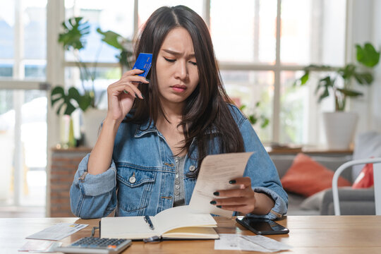 Woman doing accounting home finance expenses and calculate credit card monthly debt to bills payment.