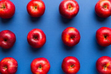 Many red apples on colored background, top view. Autumn pattern with fresh apple above view