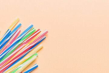 Heap of colorful plastic drinking straws on Colored background, flat lay. Copy Space for text