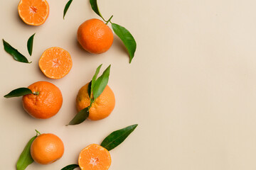 Many fresh ripe mandarin with green leaves on colored background, top view, space for text