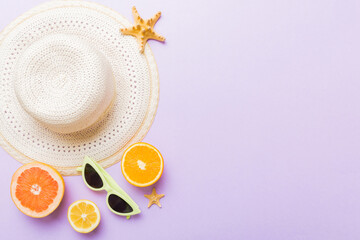 Top view of various seashells placed near colorful fruit and stylish summer accessories on table background. Summer concept. Flat lay. Top view with copy space for text