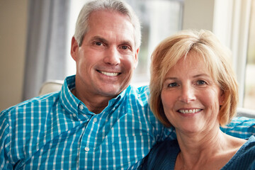 Sofa, happy and portrait of mature couple for bonding, loving relationship and relax together in home. Marriage, love and man and woman on couch for affection, embrace and romance in living room