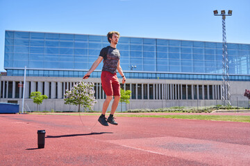 full view of a man jumping rope in an outdoor training session