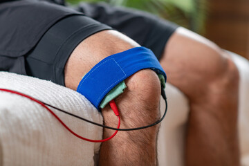 A patient undergoing knee therapy with electrotherapy treatment for pain relief and rehabilitation.