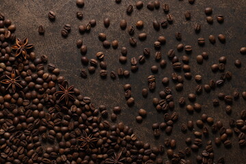 Coffee beans scattered on a textured brown background. View from above. Flat lay
