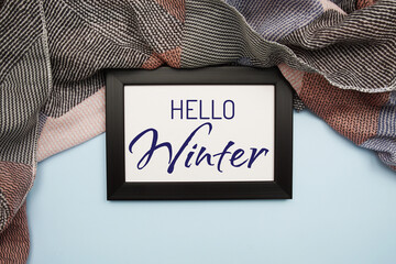 Hello Winter text message with scarft on blue background