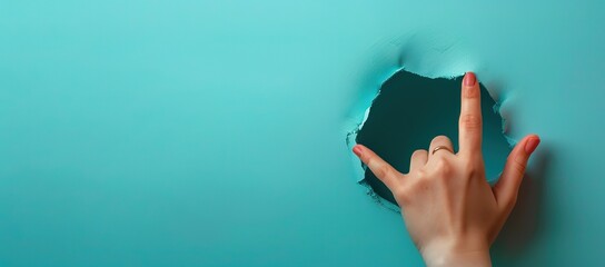 A hand in front of a wall with a green hole