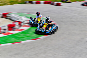 Young racers competing with karts on a Karting circuit in Barcelona. Lifestyle. Motion effect