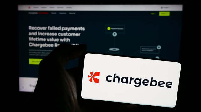 Stuttgart, Germany - 06-03-2024: Person holding mobile phone with logo of American revenue growth management company Chargebee Inc. in front of web page. Focus on phone display.