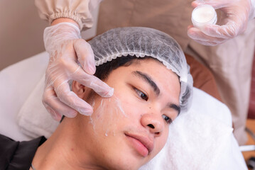 Applying cream on a male patient for a radio frequency facial treatment. RF skin tightening procedures.