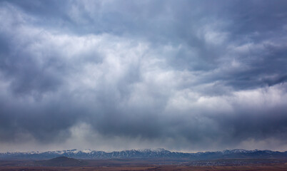Rain clouds over a mountain range in the distance. Change of weather in the rainy season. Thunderclouds, an approaching storm.