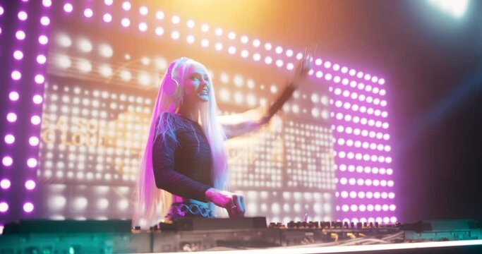 Empowering Girl Performing at a DJ Concert Live on Stage. Talented Music Producer Dancing, Mixing Energetic Dance Hits on Turntables. Young Beautiful Female Engaging with the Crowd
