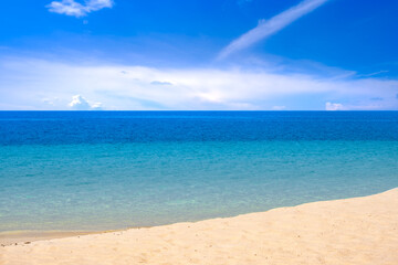 Top view of sandy beach for summer vacation concept. Nature of the beach and sea in summer with sunlight, and light sand. The sea sparkles against the blue sky. Sandy Beach for summer vacation concept