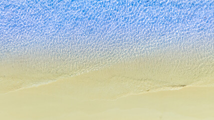 Top view beach sand background for summer vacation concept. Beach nature and summer seawater with sunlight light sandy beach Sparkling sea water	