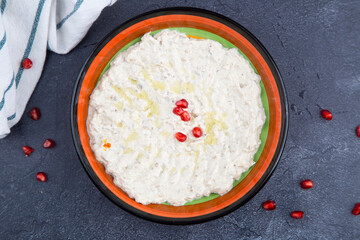mutabal Turkish cuisine on wooden table with pomegranate