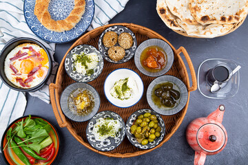 Middle eastern, Turkish or arabic Breakfast and assorted meze, concrete rustic background. Meat kebab, falafel, baba ghanoush, muhammara, hummus, sambusak, rice, tahina, kibbeh, pita. Lebanese cuisine