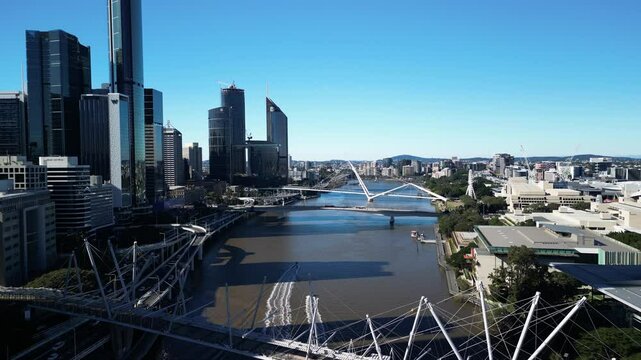 Brisbane City office high-risers towering over the Brisbane River and connecting bridges. Moving drone view
